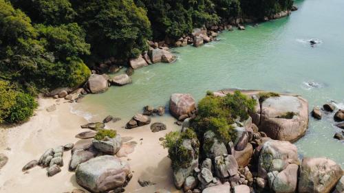 a group of rocks on a beach next to a river at Apartamento em Governador Celso Ramos in Governador Celso Ramos