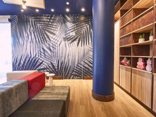 a living room with a blue pillar and a couch at Ibis Elche in Elche