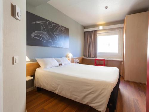 a hotel room with a large bed in it at Ibis Elche in Elche