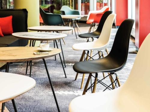 a row of tables and chairs in a restaurant at ibis München Parkstadt Schwabing in Munich