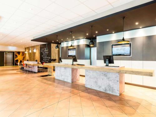a lobby with a reception desk in a building at ibis München Parkstadt Schwabing in Munich