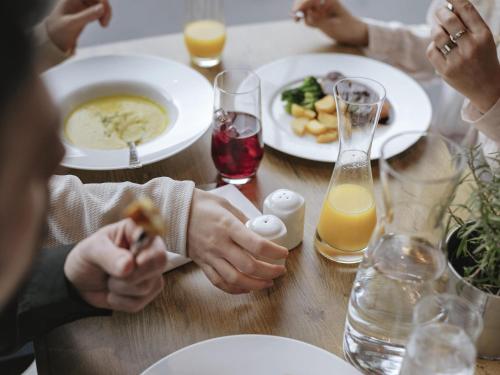 a group of people sitting at a table eating food at ibis budget Basel Pratteln in Pratteln