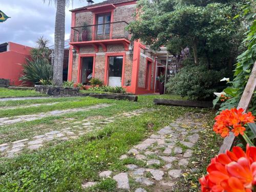 a red house with a walkway in front of it at Pousada Raio de Sol in Jaguarão