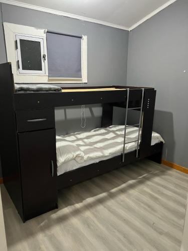 a black bunk bed in a room with a window at La MERCED 