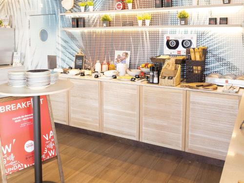 a kitchen with wooden cabinets and plates on the counter at Ibis Elche in Elche