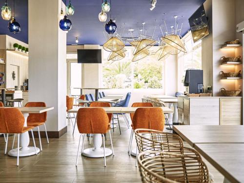 a restaurant with tables and chairs and a kitchen at Ibis Elche in Elche