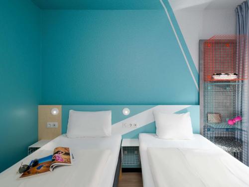 two beds in a room with blue walls at ibis budget Hamburg St Pauli Messe - neu renoviert in Hamburg