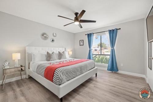a white bedroom with a bed and a ceiling fan at 4BR Chula Vista Getaway Splash, Play & Game! in Chula Vista