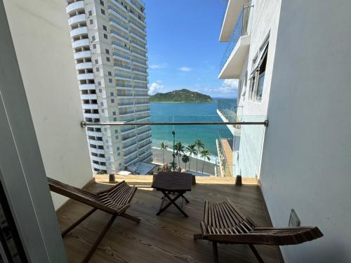 a balcony with two chairs and a view of the ocean at Departamento a pie de playa en Camino al Mar in Mazatlán