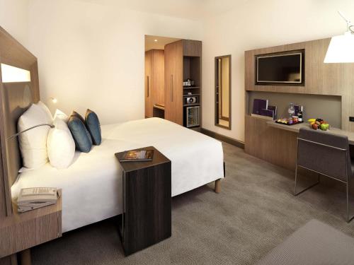 a hotel room with a large bed and a desk at Novotel World Trade Centre Dubai in Dubai