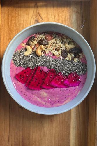 a bowl filled with a pink dessert on a wooden table at Widji Garden Villa in Uluwatu