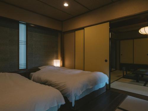 a hotel room with two beds and a window at Ujosouan in Kyotango