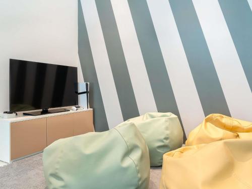 a living room with a television and two chairs at Novotel World Trade Centre Dubai in Dubai
