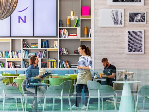 a group of people sitting at tables in a library at Novotel Monte-Carlo in Monte Carlo