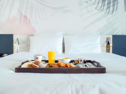 a tray of food and drinks on a bed at Novotel Monte-Carlo in Monte Carlo