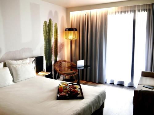 a hotel room with a bed with a tray of food on it at Novotel Monte-Carlo in Monte Carlo