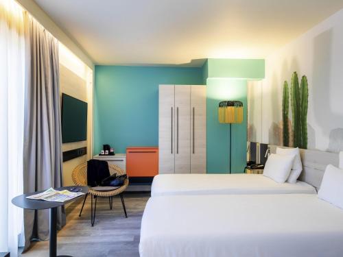 a hotel room with two beds and a table at Novotel Monte-Carlo in Monte Carlo