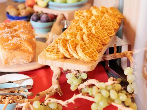 a buffet with waffles and grapes on a table at Novotel Monte-Carlo in Monte Carlo
