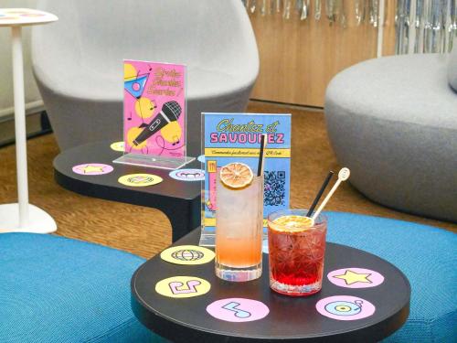 a table with a drink and a book on it at Novotel Monte-Carlo in Monte Carlo