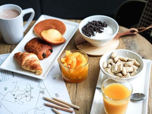 a table with two plates of breakfast foods and a cup of coffee at ibis Caen Porte De Bretagne in Bretteville-sur-Odon