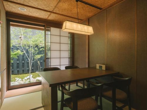 a dining room with a table and chairs and a window at Ujosouan in Kyotango