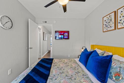 a bedroom with a bed with blue pillows and a clock at 4BR Chula Vista Getaway Splash, Play & Game! in Chula Vista