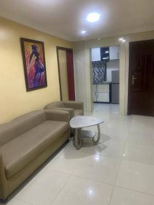 una sala de estar con un sofá y una mesa en Peony Apartment, en Lagos