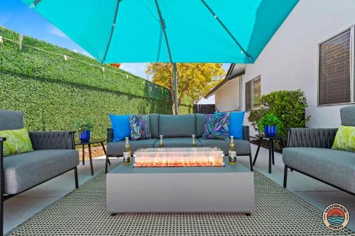 a patio with blue couches and an umbrella at 4BR Chula Vista Getaway Splash, Play & Game! in Chula Vista
