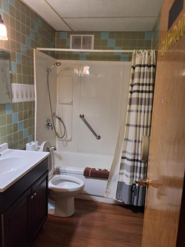a bathroom with a shower and a toilet and a sink at Wildwood Hotel in Wildwood