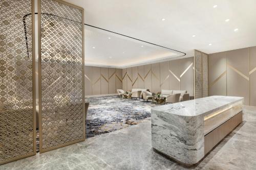 a lobby with a marble counter and a waiting room at Sheraton Surabaya Hotel & Towers in Surabaya