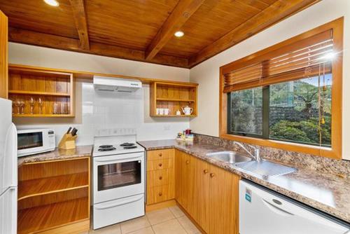 a kitchen with white appliances and a window at Oreti Village Resort in Kuratau