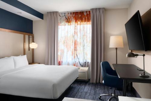 a hotel room with a bed and a desk and a window at Fairfield Inn and Suites Sacramento Airport Natomas in Sacramento