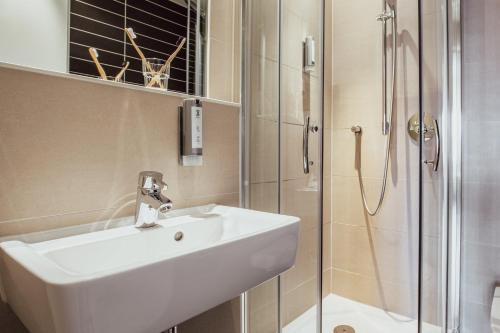 a bathroom with a sink and a shower at Garner Hotel Berlin - Charlottenburg, an IHG Hotel in Berlin