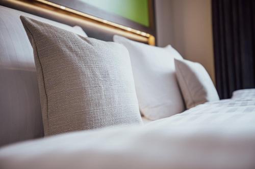 a white bed with white pillows on it at Garner Hotel Berlin - Charlottenburg, an IHG Hotel in Berlin