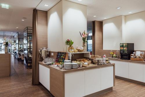 a restaurant with a counter with food on it at Garner Hotel Berlin - Charlottenburg, an IHG Hotel in Berlin