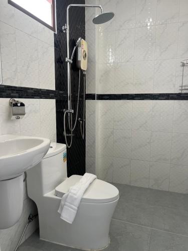 a bathroom with a toilet and a sink and a shower at J2 Airport Mansion in Nai Yang Beach