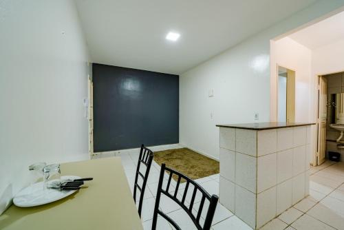 a kitchen with a table and chairs and a blackboard at Flat c Wi-Fi e Ar-condicionado Perto do Aeroporto in Fortaleza