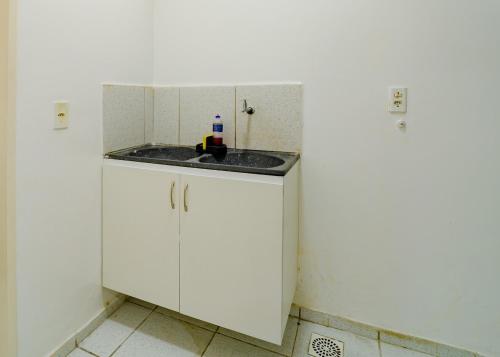 a white kitchen with a sink in a room at Flat c Wi-Fi e Ar-condicionado Perto do Aeroporto in Fortaleza
