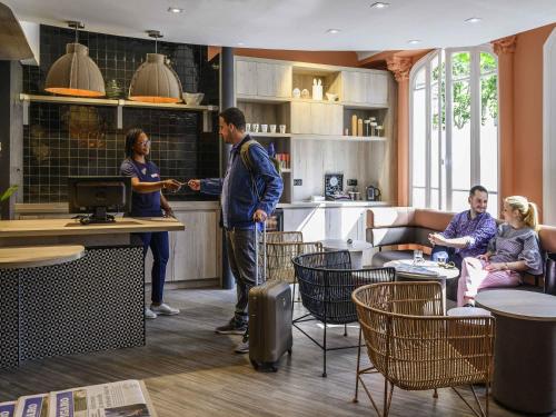 a group of people standing in a room at ibis Paris Tour Montparnasse 15eme in Paris