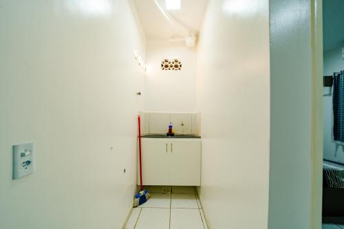 a small kitchen with white walls and a white floor at Flat com Wi-Fi proximo ao Aeroporto in Fortaleza