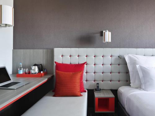 a hotel room with a bed and a desk with a laptop at Pullman London St Pancras in London
