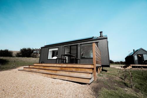 a black tiny house sitting on top of a field at Swell At Cape Bridgewater in Cape Bridgewater