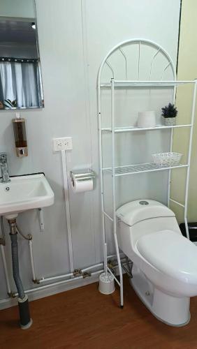 a bathroom with a white toilet and a sink at Apartamentos Modular Bahía Ballena in Bahia