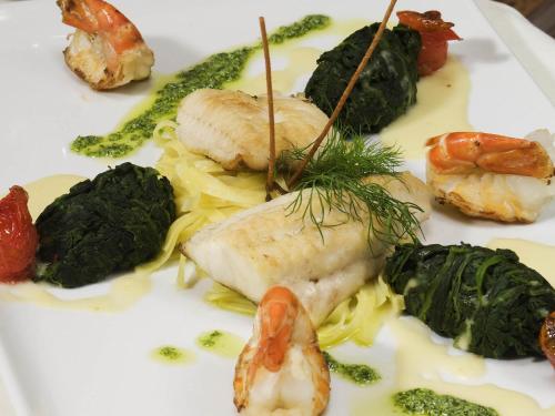 a white plate of food with shrimp and vegetables at Mercure Hotel Bad Duerkheim An Den Salinen in Bad Dürkheim
