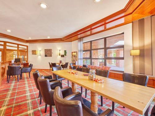 a restaurant with a long table and chairs at Mercure Hotel Bad Duerkheim An Den Salinen in Bad Dürkheim