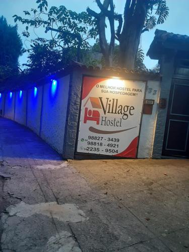 a sign for a village hospital on a wall at Pousada Village Hostel in Petrópolis
