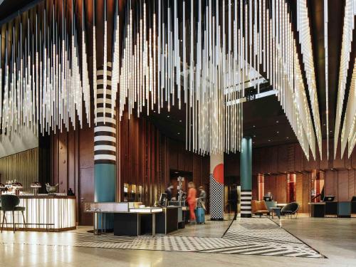 a lobby with lots of chandeliers hanging from the ceiling at Pullman Berlin Schweizerhof in Berlin