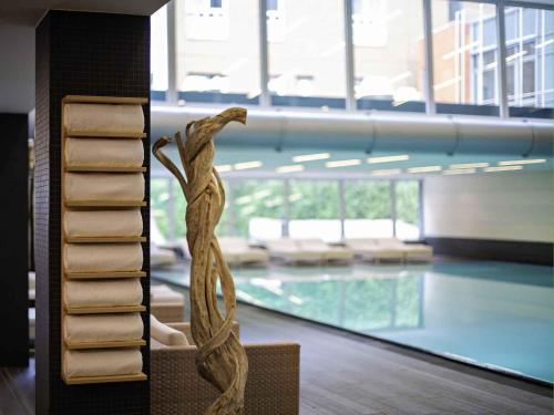a statue of a woman standing in front of a swimming pool at Pullman Berlin Schweizerhof in Berlin