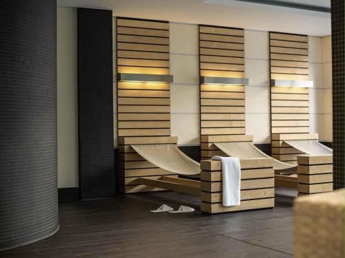 a bathroom with wooden shelves and white towels at Pullman Berlin Schweizerhof in Berlin