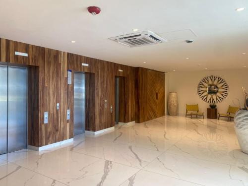 a lobby with wooden walls and a glass door with a mirror at Departamento a pie de playa en Camino al Mar in Mazatlán